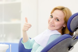 A young girl in the exam chair at a dental office.